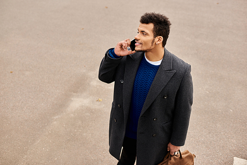 Man enjoys a conversation on the phone while looking relaxed in his fashionable attire.