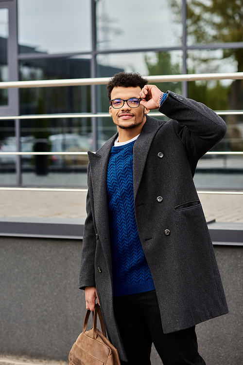 Young man confidently poses outdoors, showcasing his unique fashion and charm in a bustling area.