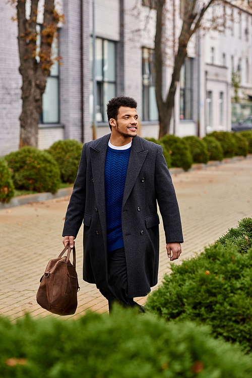 A well dressed man strolls leisurely through a charming, green urban neighborhood.