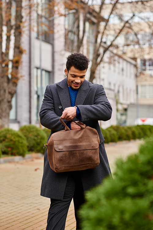 Man dressed warmly enjoys a moment outdoors, looking into a stylish bag with a smile.