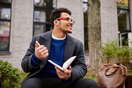 Man reads a book with enthusiasm while relaxing at a charming urban park setting.