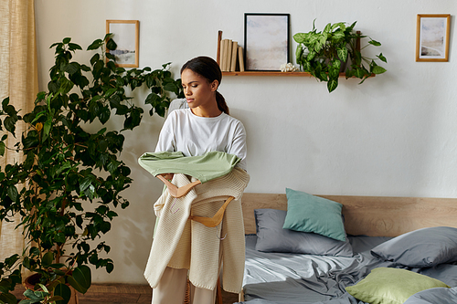 A young African American woman is organizing her space, engaging in daily cleaning tasks.