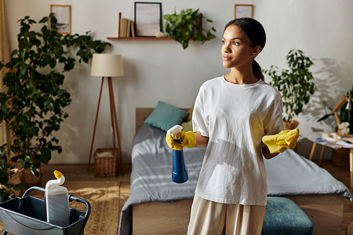 In a stylish apartment, a young woman engages in cleaning chores while smiling with purpose.