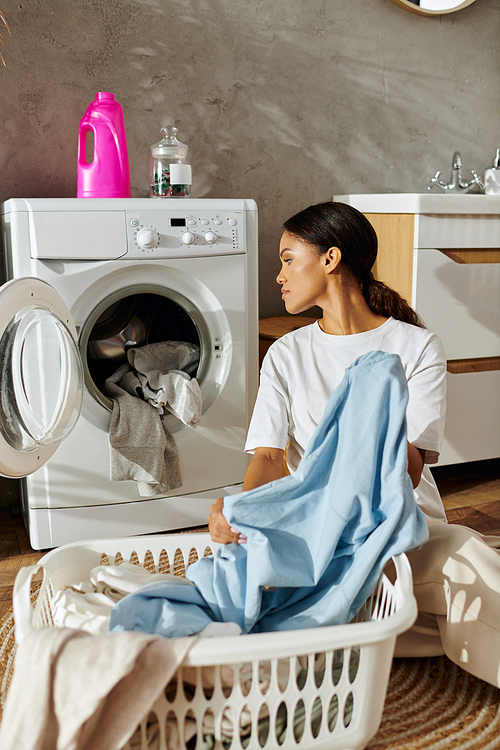 A young african american woman sorts laundry in her stylish apartment, embracing daily chores.