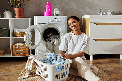 In a stylish apartment, a young woman is happily sorting laundry in a basket.