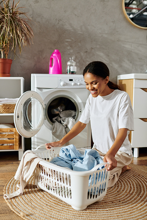 A young African American woman happily organizes her laundry in a stylish apartment interior.