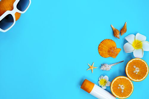 Beautiful summer holiday, Beach accessories, orange, shells and sunblock on blue backgrounds