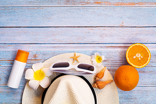 Beautiful summer holiday, Beach accessories, sunglasses, hat, sunblock and orange on wooden backgrounds