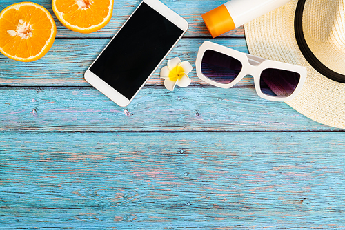 Beautiful summer holiday, Beach accessories, orange, sunglasses, hat, sunblock and smartphone on wooden backgrounds