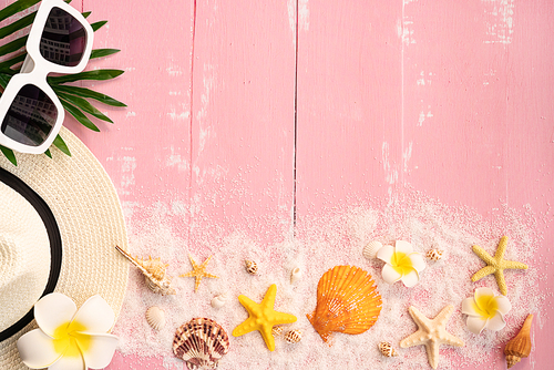 Beautiful summer holiday, Beach accessories, seashells, sand, hat, sunglasses and palm leave on wooden backgrounds