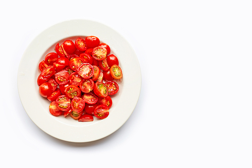 Fresh tomatoes, half cut on white dish.  Copy space