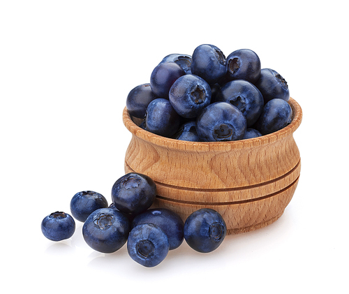 Blueberry isolated on white. A pile of fresh blueberries in a wooden bowl, fresh wild berries, ideal for use in packaging, close-up