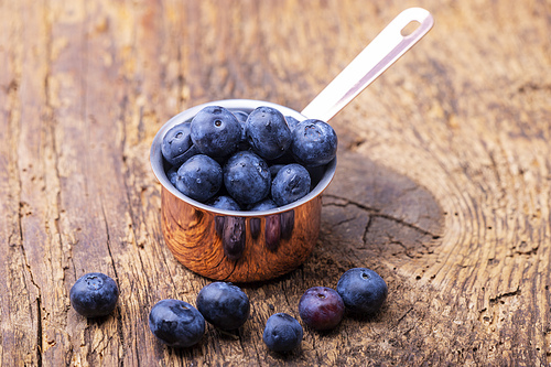 blue berries in a pot on wood