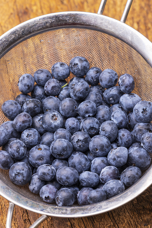 blue berries in a pot on wood