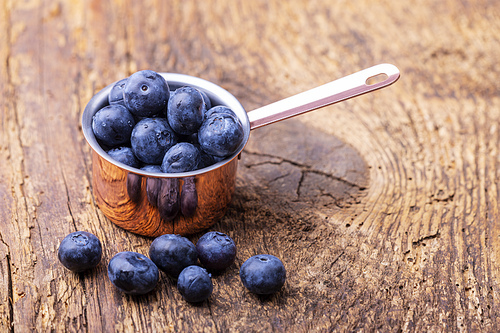 blue berries in a pot on wood