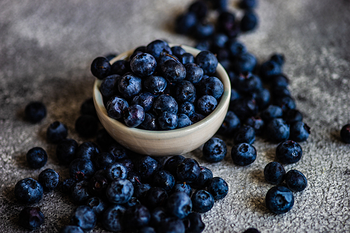 Organic food concept with ripe blueberry on rusty stone background