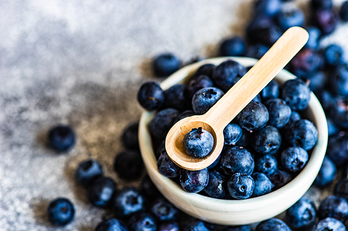 Organic food concept with ripe blueberry on rusty stone background