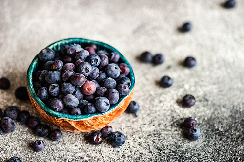 Organic food concept with ripe blueberry on rusty stone background