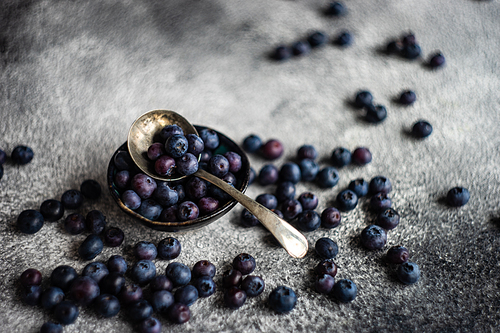 Organic food concept with ripe blueberry on rusty stone background