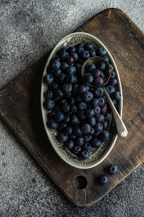 Organic food concept with ripe blueberry on rusty stone background