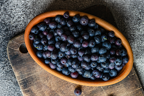 Organic food concept with ripe blueberry on rusty stone background