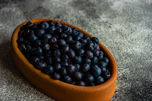 Organic food concept with ripe blueberry on rusty stone background