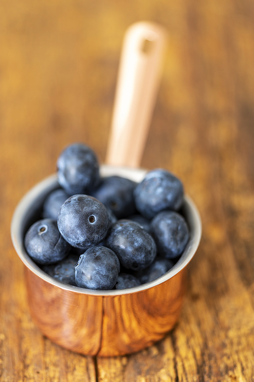 blue berries in a pot on wood