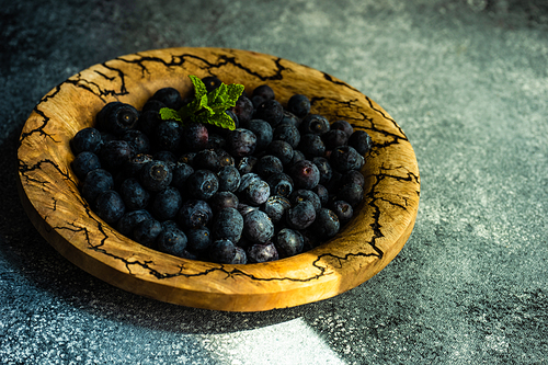 Organic blueberry fruits on concrete background with copy space