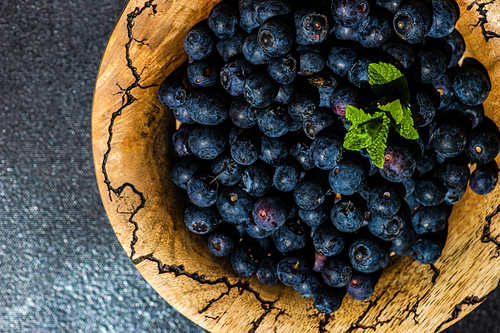 Organic blueberry fruits on concrete background with copy space