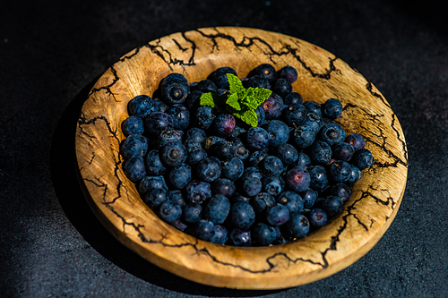 Organic blueberry fruits on concrete background with copy space