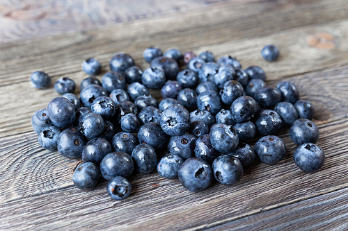 Blueberries on rustic wooden cozy background. Fresh-gathered berries full of vitamins, good for diet nutrition and healthy meals.