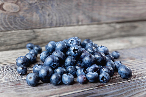 Blueberries on rustic wooden cozy background. Fresh-gathered berries full of vitamins, good for diet nutrition and healthy meals.