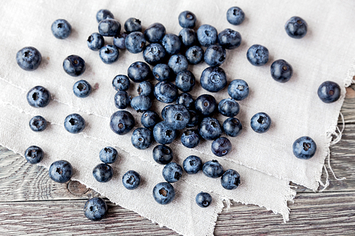 blueberries lie on homespun tablecloth. rustic cozy background with healthy food. fresh-gathered berries full of vitamins, good for  nutrition and healthy meals.