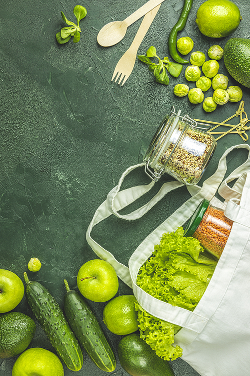 Zero waste concept. Eco-friendly shopping, flat lay. Fresh organic green vegetables and fruits on green background. Spring diet, healthy raw vegetarian, vegan concept, alkaline clean eating