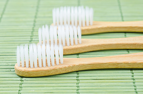 Bamboo toothbrushes on bamboo mat backgroud.