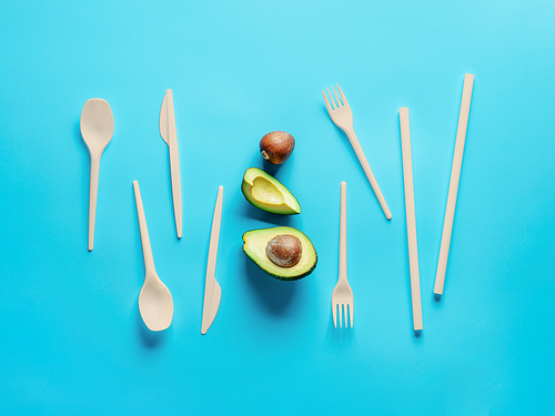 Avocado Seeds Biodegradable Single-Use Cutlery. Bioplastic - Great alternative to plastic disposable cutlery. Minimal concept on blue background.