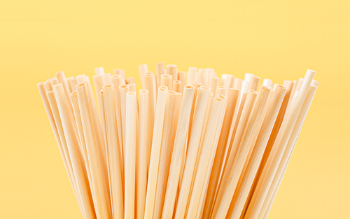 close up wheat straws for  water natural eco friendly renewable on yellow background.