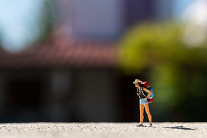 Miniature people :  Traveler with backpack standing on The road . Travel Concept