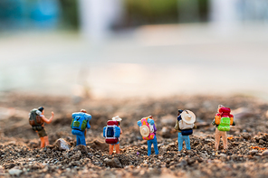 Miniature people : Traveler with backpack mountaineering. Hiking man with backpack walking outdoor