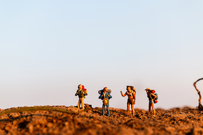 Miniature people : Traveler with backpack mountaineering. Hiking man with backpack walking outdoor