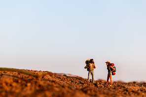 Miniature people : Traveler with backpack mountaineering. Hiking man with backpack walking outdoor