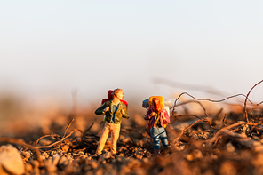 Miniature people : Traveler with backpack mountaineering. Hiking man with backpack walking outdoor