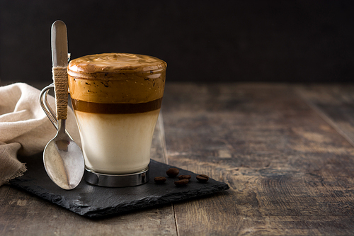 Creamy iced dalgona coffee on wooden table