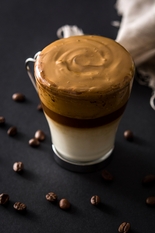 Creamy iced dalgona coffee on black background