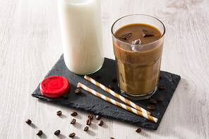 Iced coffee or caffe latte in a tall glass on wooden table