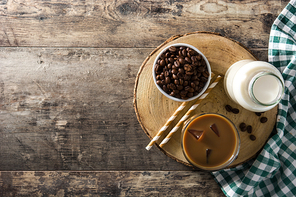 Iced coffee or caffe latte in tall glass on wooden table.