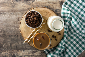 Iced coffee or caffe latte in tall glass on wooden table.