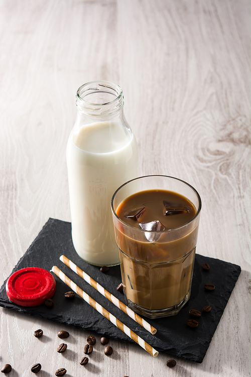 Iced coffee or caffe latte in a tall glass on wooden table