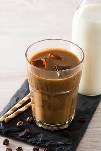 Iced coffee or caffe latte in a tall glass on wooden table