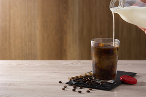 Preparing iced coffee or caffe latte on wooden table